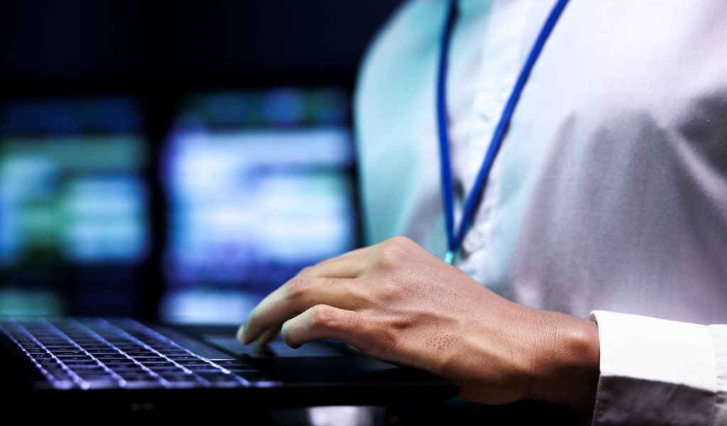 expert using laptop to analyze servers